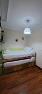 a small bed in a room with a light at Apartamento Marichu in Melide