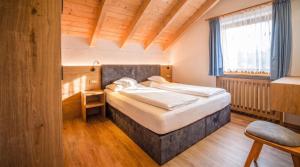 a bedroom with a large bed in a room at Apartments Lasteis in La Villa