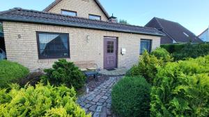 a house with a purple door and a bench at Ferienwohnung Erika in Usedom Town