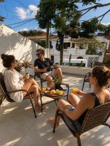 a group of people sitting in chairs on a patio at Pousada Narval Buzios in Búzios