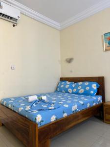 a bedroom with a bed with a blue comforter at Residence samy in San-Pédro