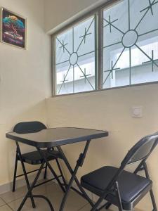 a table and two chairs in front of a window at Residence samy in San-Pédro