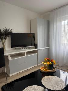 a living room with a tv on a white cabinet at Apartment Ventspils iela 22 in Rēzekne +6 photos