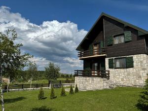 a house on a hill with a green yard at Wolf Chalet in Motički Gaj
