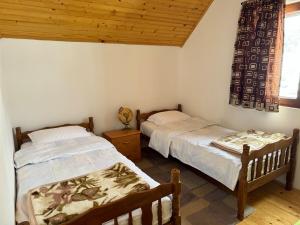 a bedroom with two beds and a wooden ceiling at Wolf Chalet in Motički Gaj