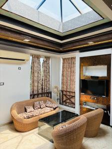 a living room with two couches and a tv at Villa Clasic Comfort in Navalur