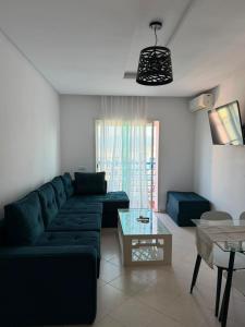 a living room with a blue couch and a table at Peaceful Home in Cabo Negro +8 photos