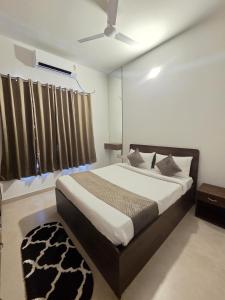 a bedroom with a bed and a ceiling fan at Villa Clasic Comfort in Navalur +26 photos