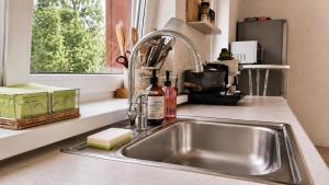 a stainless steel sink in a kitchen with a window at Suur ja Hubane maja, Saaremaal in Saareküla +20 photos