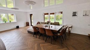 a dining room with a wooden table and chairs at Suur ja Hubane maja, Saaremaal in Saareküla
