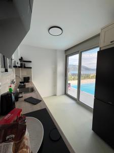 a kitchen with a large window with a view of a pool at Almira Seaside Suites in Áyios Dhimítrios