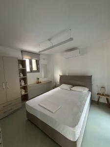 a white bedroom with a large white bed in it at Almira Seaside Suites in Áyios Dhimítrios +51 photos