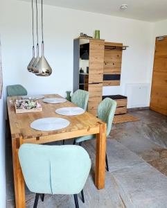 a dining room with a wooden table and chairs at Exclusive Apartment mit Alpenpanorama in Peiting +15 photos