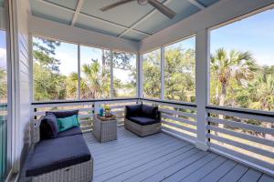 a screened porch with a bed and a chair at Nature's Touch in Edisto Island