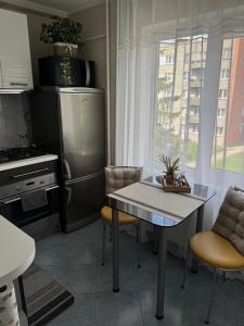 a kitchen with a table and chairs and a refrigerator at Apartment Ventspils iela 22 in Rēzekne