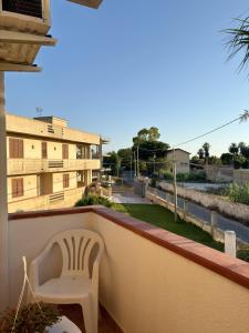 a white chair sitting on the balcony of a building at Casa Calipa in Marsala