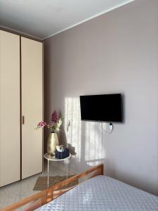 a bedroom with a bed and a tv on the wall at Casa Calipa in Marsala