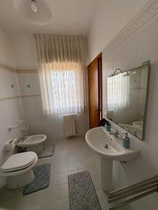 a white bathroom with a toilet and a sink at Casa Calipa in Marsala +21 photos