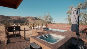 a hot tub on a wooden deck with an umbrella at Zenity Joshua tree in Joshua Tree