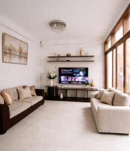 a living room with two couches and a flat screen tv at Casa Deluxe Hotel Talara in Talara