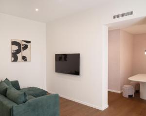 a living room with a couch and a tv on a wall at Fill's Luxury Design Apartments 100m from the Beach in Rimini