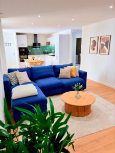 a living room with a blue couch and a coffee table at Le Salon des Voyageurs - Appartement Climatisé avec Terrasse et Parking Gratuit à Proximité in Dole