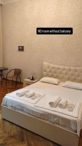 a bedroom with a bed with two towels on it at Liberty Apartment And Rooms in Tbilisi City