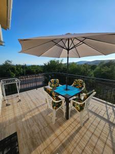 a table and chairs with an umbrella on a deck at Gabi in Ðuraševići +9 photos