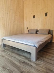 a large bed in a room with wooden walls at Jaunmāriņi in Liepāja