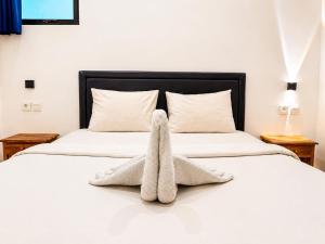 a bed with a towel animal sitting on it at Suardana Inn's in Kuta +25 photos