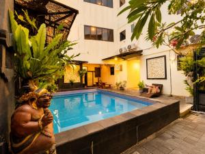 a pool with a statue next to a building at Suardana Inn's in Kuta