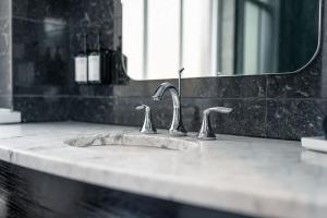 a bathroom sink with two faucets and a mirror at NoMad Studio Near Broadway & Madison Square in New York +36 photos