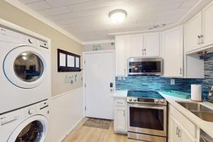 a kitchen with white cabinets and a washer and dryer at Fiddlers Cove 6J in Hilton Head Island +17 photos