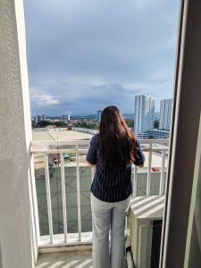 a woman standing on a balcony looking out at the city at inspiria condo davao 14th in Davao City