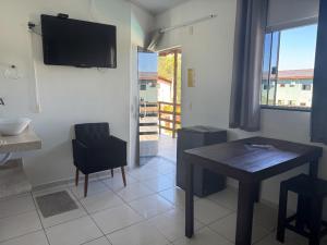 a dining room with a table and a television on a wall at Pousada Sunflower in Pirenópolis