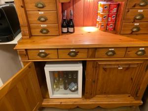 a wooden cabinet with a drawer filled with wine bottles at 't Westerkwartiertje in Aduard