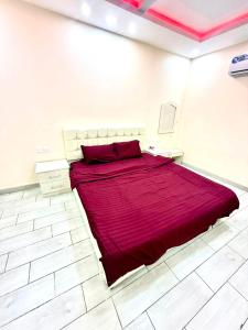 a large red bed in a white room at شاليهات زارا 2 in Taif +4 photos