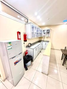 a kitchen with a refrigerator and a table at شاليهات زارا 2 in Taif