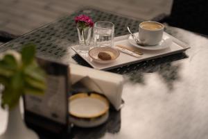 a table with a plate of food and a cup of coffee at Forelle Restaurant & Motel in Çuxuryurd