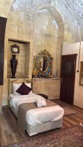 a bedroom with a bed with a mirror on the wall at antik senyora butik in Urfa