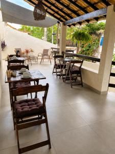 an outdoor patio with tables and chairs and a table and chairs at Pousada Narval Buzios in Búzios
