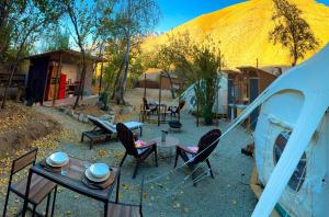 a patio with a table and chairs and a tent at Glamping Ramas De Elqui in Pisco Elqui