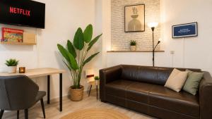 a living room with a brown leather couch and a table at Beesenkammer - zentrales StudioApartment Halle in Halle an der Saale