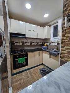 a kitchen with white cabinets and an oven at Appartement Birkhadem in Birkhadem