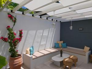 a room with a bench and a table and flowers at Astre&Jeanne suites in Sozopoli