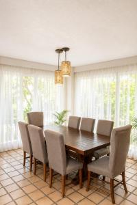 a dining room with a wooden table and chairs at The White Villa in Cancún