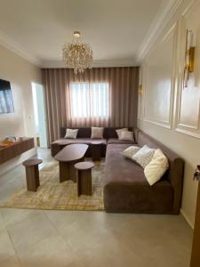 a living room with a couch and a table at Super Appartement Sidi Rhal in Dar Hamida