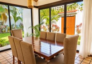 a dining room with a table and chairs and large windows at Ocean Bloom in Cancún