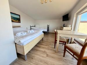 a room with two beds and a table and a dining room at Pokoje Gościnne Angelika in Swarzewo +47 photos