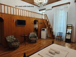 a living room with a staircase and a table and chairs at Liberty Apartment And Rooms in Tbilisi City